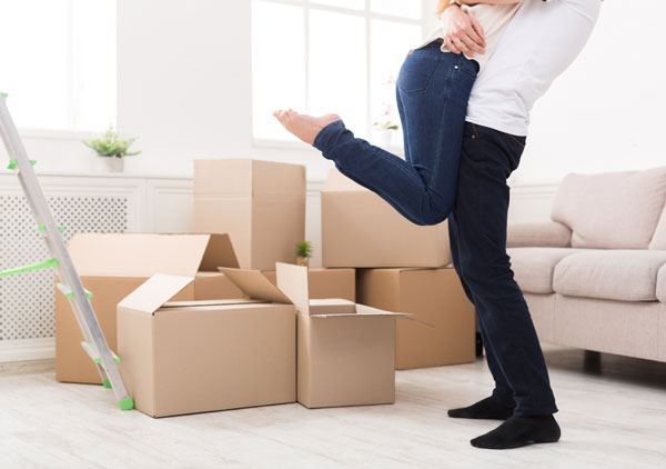 Happy couple hugging near unpacked boxes